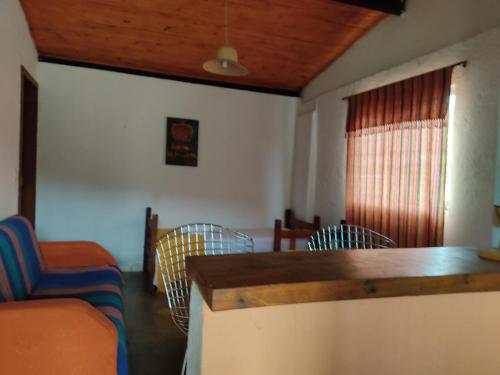 a living room with chairs and a table and a window at Pouso do Elefante in Serra do Cipo