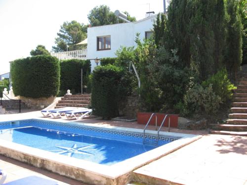 a swimming pool in front of a house at Belvilla by OYO La Pineda in Begur