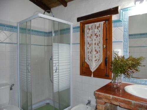 La BorregaにあるComfy Farmhouse in Valencia de Alc ntara with Poolのバスルーム(ガラス張りのシャワー、シンク付)