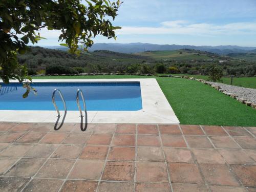 a swimming pool with a view of the hills at Belvilla by OYO El Trigal in Villanueva de la Concepción