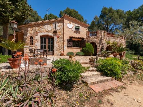 ein Steinhaus mit einem Garten und einer Terrasse in der Unterkunft Belvilla by OYO Can Vives in Palafrugell