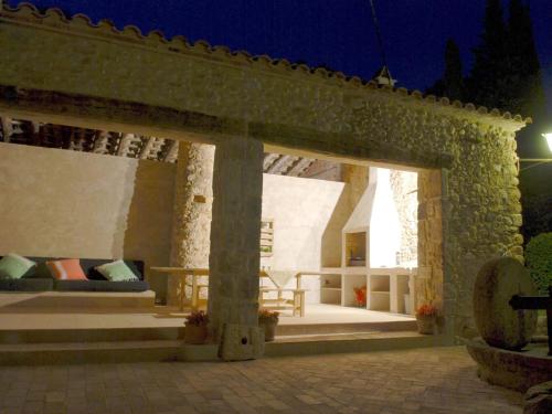 a stone building with a patio at night at Spacious Home in Navata in Navata