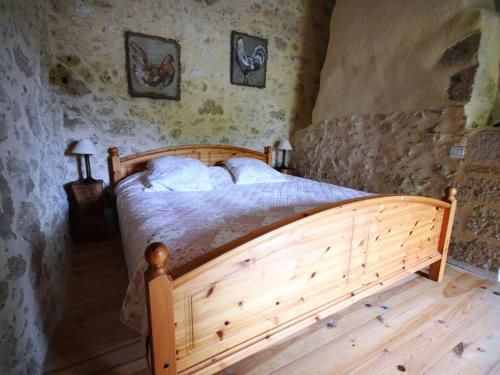 a bedroom with a wooden bed in a room at Cozy House in Lot with Pool and Terrace in Saint-Caprais-de-Lerm