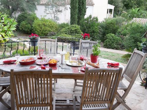 een houten tafel met eten erop met twee stoelen bij villa with private swimming pool in Roquebrun