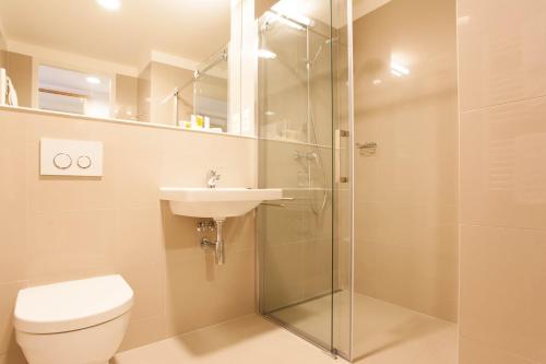 a bathroom with a shower and a toilet and a sink at Hotel S-PORT Véska in Dolany