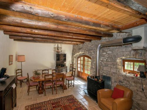 sala de estar con mesa y pared de piedra en Beautiful farmhouse in mountain forest setting en Saint-Bonnet-le-Froid