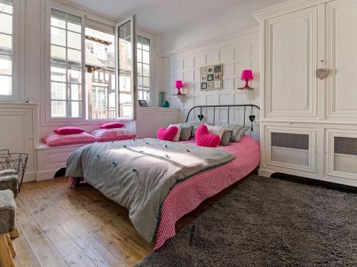 une chambre avec un grand lit avec des oreillers roses dans l'établissement Apartment in Isigny near Cotentin Marshes, à Isigny-sur-Mer