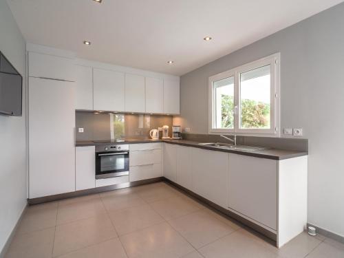 une cuisine avec des armoires blanches et une fenêtre dans l'établissement Villa in Occitanie with Private Pool, à Saint-Geniès-de-Fontedit