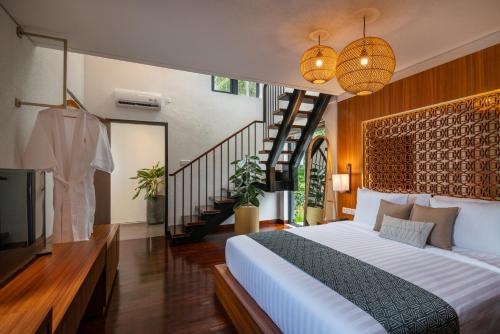 a bedroom with a bed and a tv and stairs at Zenubud in Ubud