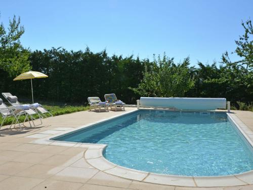 a swimming pool with chairs and an umbrella at Comfortable villa in Coux with private pool in Privas
