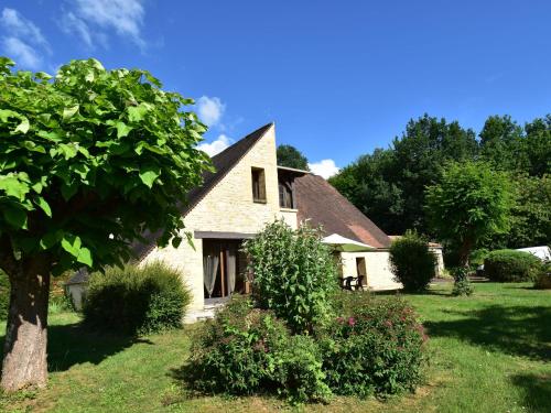 a white house with a tree in the yard at Gorgeous Villa in St Julien De Lampon with Private Pool Centre Nearby in Carlux