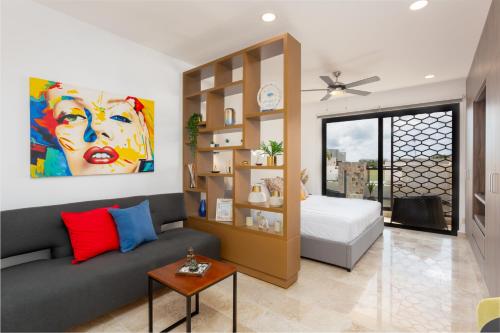un salon avec un canapé et un lit dans l'établissement Studio Vanessa beach 42 a 1 min de la playa y 5ta av, à Playa del Carmen