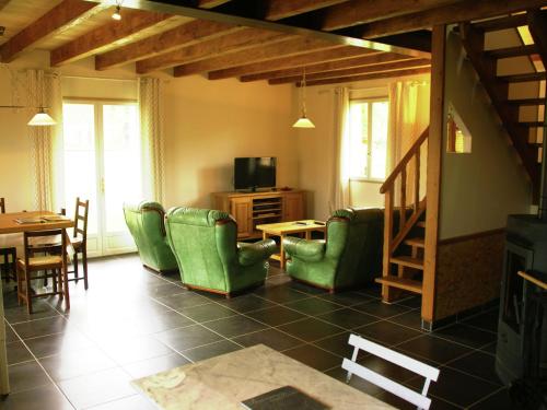 Modern holiday home with private pool في Loubressac: غرفة معيشة مع كراسي خضراء وطاولة