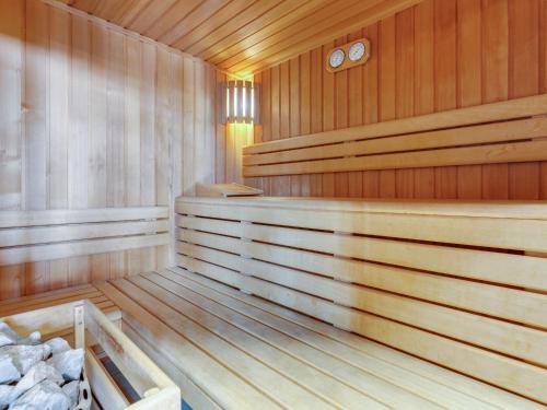 an empty wooden sauna with two clocks at Loft with jacuzzi and sauna in Niderviller