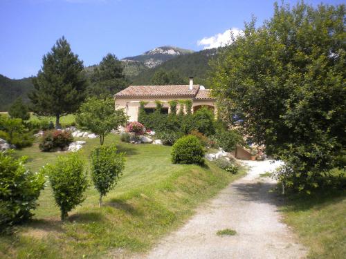 uma casa num jardim com árvores e uma estrada de terra em Quiet holiday home with garden em Ponet-et-Saint-Auban