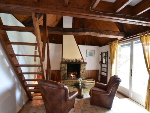 a living room with leather chairs and a fireplace at Lovely holiday home with garden terrace and fantastic view in Guilberville in Fourneaux