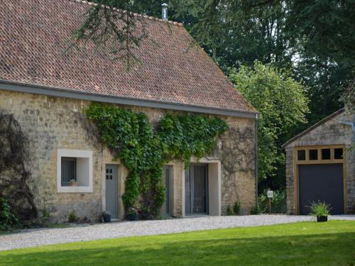 a stone house with ivy on the side of it at Holiday home with private garden in Wierre Effroy in Rinxent