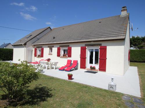 een huis met rode deuren en een patio bij Holiday home in Denneville near the beach in Denneville