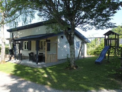 a small house with a slide and a playground at Modern holiday home with lovely garden in Saint-Honoré-les-Bains