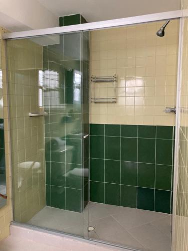 a shower with a glass door in a bathroom at Roomies House By Rincon in Medellín