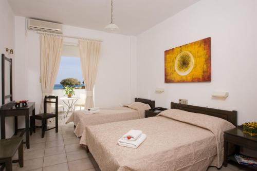 a hotel room with two beds and a view of the ocean at Akti Corali Hotel in Amoudara Herakliou