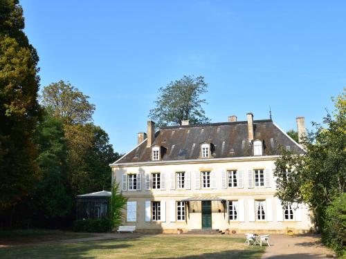 uma grande casa branca com um telhado preto em Vintage Mansion in Saint Aubin sur Loire with Pool em Bourbon-Lancy