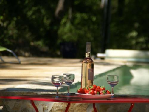 ドラギニャンにあるCharming house in the forest with private poolのワイングラス2杯とイチゴの盛り合わせ