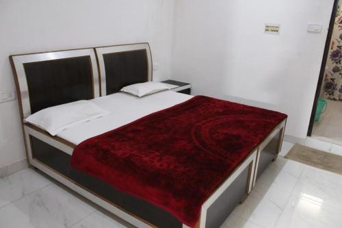 a bedroom with a large bed with a red blanket at Couple Friendly Hotel - Sunset in Orchha