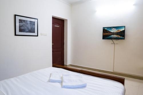 a bedroom with a bed with two towels on it at Fiji Villa in Puducherry