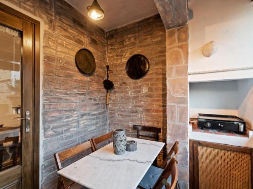 a dining room with a table and a brick wall at Apartment in Agios Nikolaos near Beach in Ayios Nikolaos Sithonia