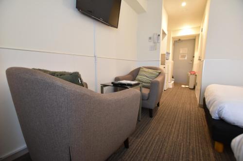 a hotel room with two chairs and a bed at Residence Condominium KALAHAAI in Tokyo