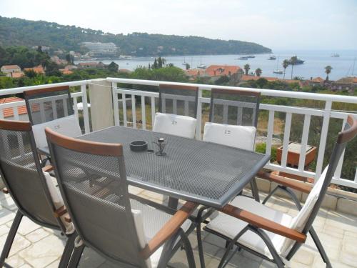 a table and chairs on a balcony with a view of the ocean at Attractive apartment in Dubrovni with balcony in Lopud Island