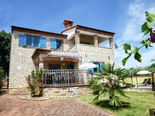 a brick house with a balcony in front of it at Lovely Villa in Ka telir Croatia with Private Pool in Labinci