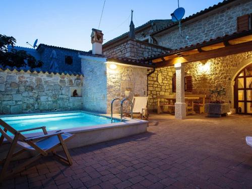 a pool in a patio with a table and chairs at Cosy holiday home in Vrsar with private pool in Marasi