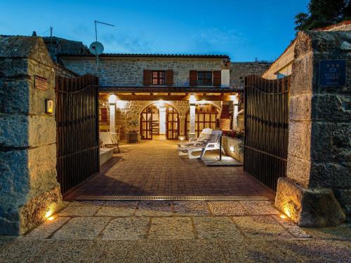 an entrance to a stone house with a gate at Cosy holiday home in Vrsar with private pool in Marasi