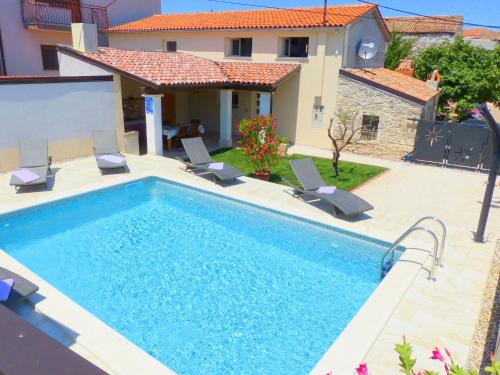a swimming pool with chairs and a house at Cozy Holiday Home in Valtura with Swimming Pool in Valtura