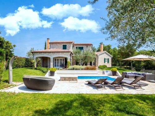 a backyard with a pool and a house at Lush Villa with Artistic Interiors Pool in Baderna