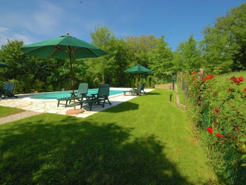 a yard with chairs and an umbrella and a pool at Cottage in Umbria with pool in Casella