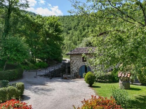 a stone building with a gate in a garden at Cottage in Umbria with pool in Casella