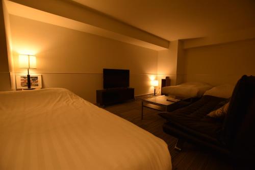 a hotel room with a bed and a couch at Residence Condominium KALAHAAI in Tokyo
