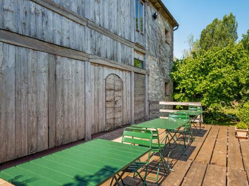 un grupo de mesas verdes contra una pared de madera en Belvilla by OYO Locanda le Querce, en Frontino
