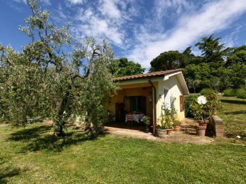 una pequeña casa amarilla en un patio con árboles en Belvilla by OYO Casaletto Graffi, en Civitella dʼAgliano