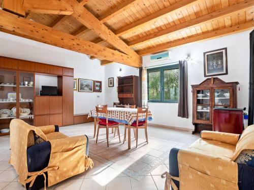 Belvilla by OYO Villa Manca في سانتا جوستا: غرفة معيشة بسقوف خشبية وطاولة وكراسي