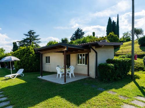 ein kleines Haus mit einem Tisch und Stühlen im Hof in der Unterkunft Apartment on Lake Garda in Manerba with Pool in Montinelle