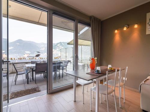 a dining room with a table and chairs and a balcony at Belvilla by OYO Casa Giada in Marone