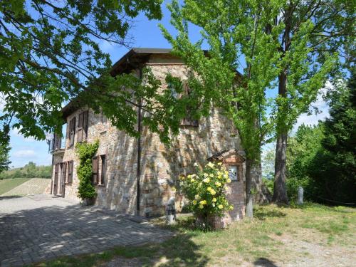 an old stone building with flowers in front of it at Belvilla by OYO Casa Magnano Ziano in Ziano Piacentino