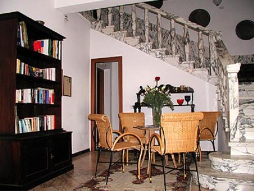 un comedor con mesa y sillas y una escalera en B&B Villa Acero en Marina di Carrara