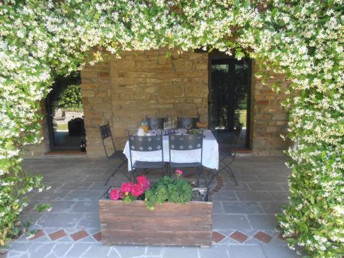 ModiglianaにあるStone house in the green rolling hills of the Apennines with gardenの花の咲くアーチのテーブル