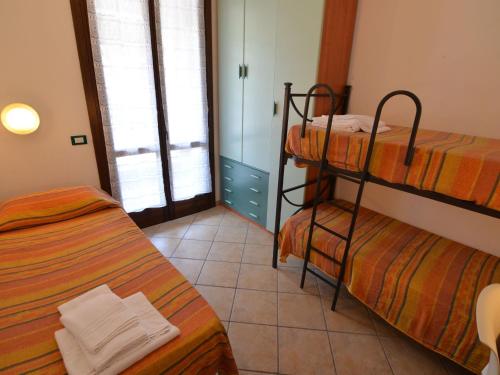 リド・ディ・スピーナにあるCheerful apartment with AC close to the Adriatic coastの二段ベッド2組が備わるタイルフロアの客室です。