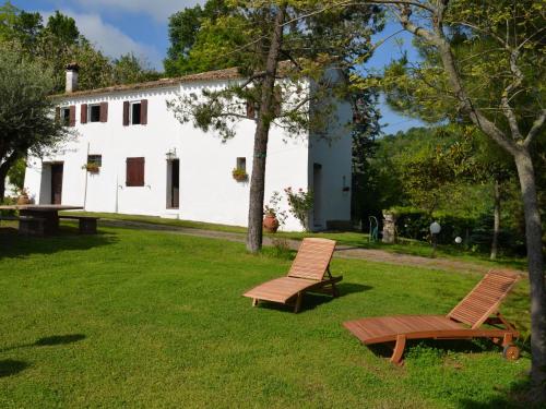 2 Stühle und ein Tisch in einem Hof mit einem weißen Gebäude in der Unterkunft Belvilla by OYO Ca Bianca in Montefiore Conca